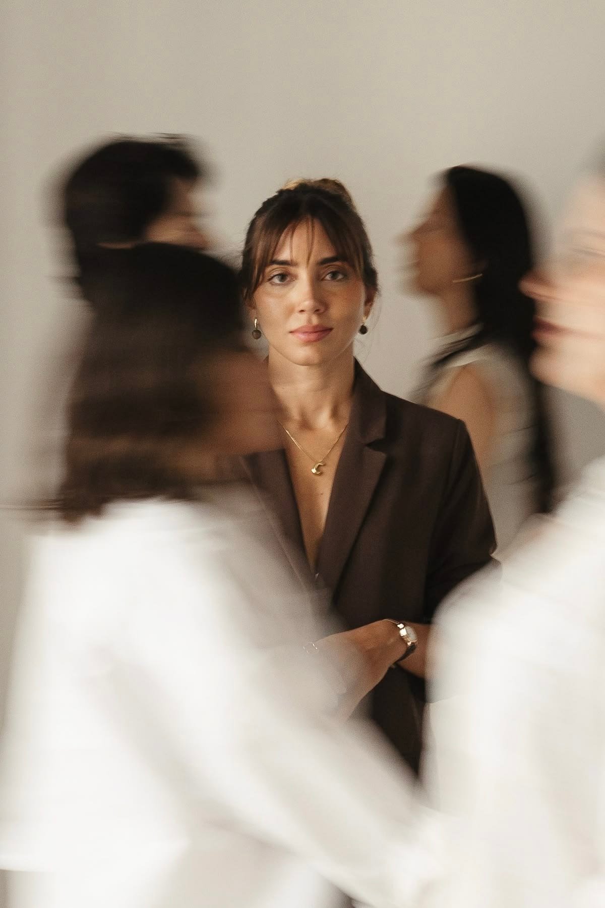 Professional woman standing in focus while colleagues move around her, representing how unconscious bias can shape workplace perception and decisions